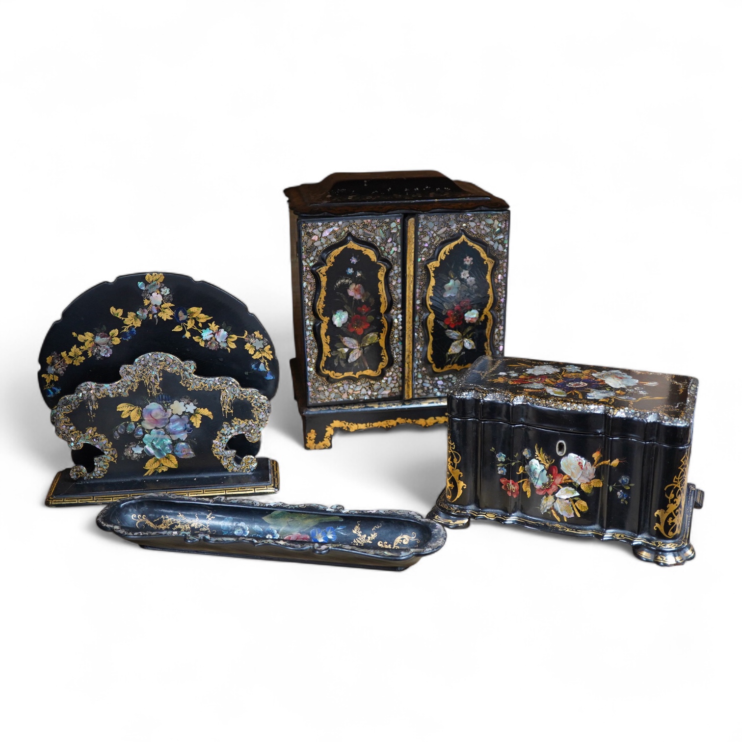 Four 19th century mother of pearl inlaid papier mache items, to include, a four drawer cabinet, 26.5cm high, a tea caddy, letter rack and pen dish